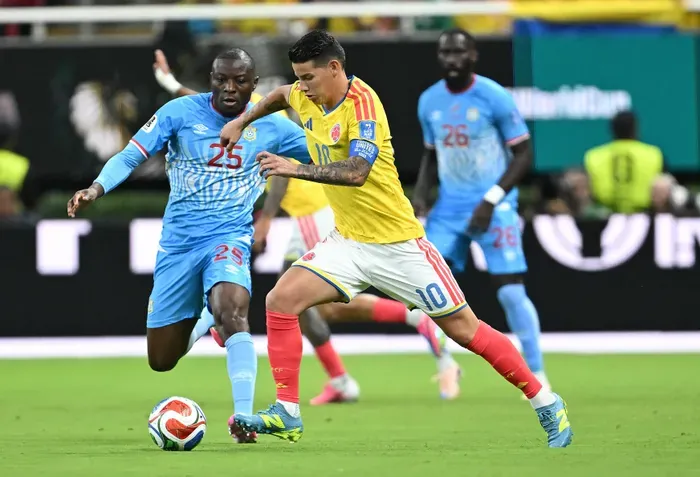 Colombia's James Rodriguez, right, vies for the ball with with DR Congo's Edo Kayembe during their Fifa World Cup match.